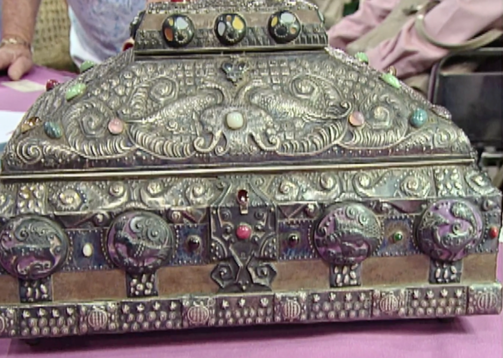 An ornate, bejeweled silver jewelry casket.