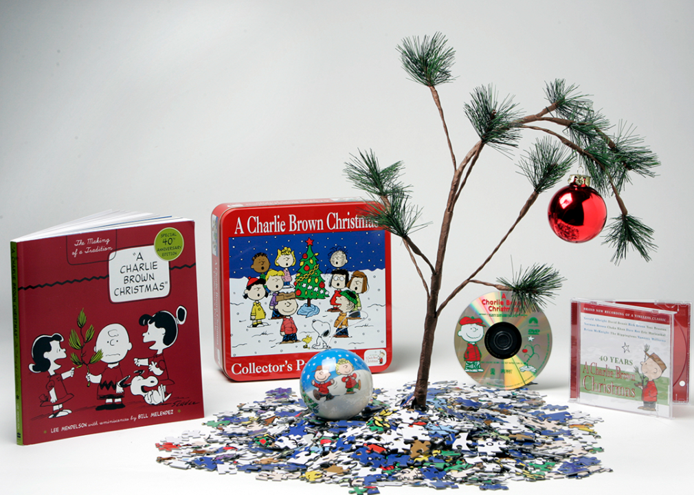 A collection of Charlie Brown Christmas books, puzzle, ornaments and other merchandise.