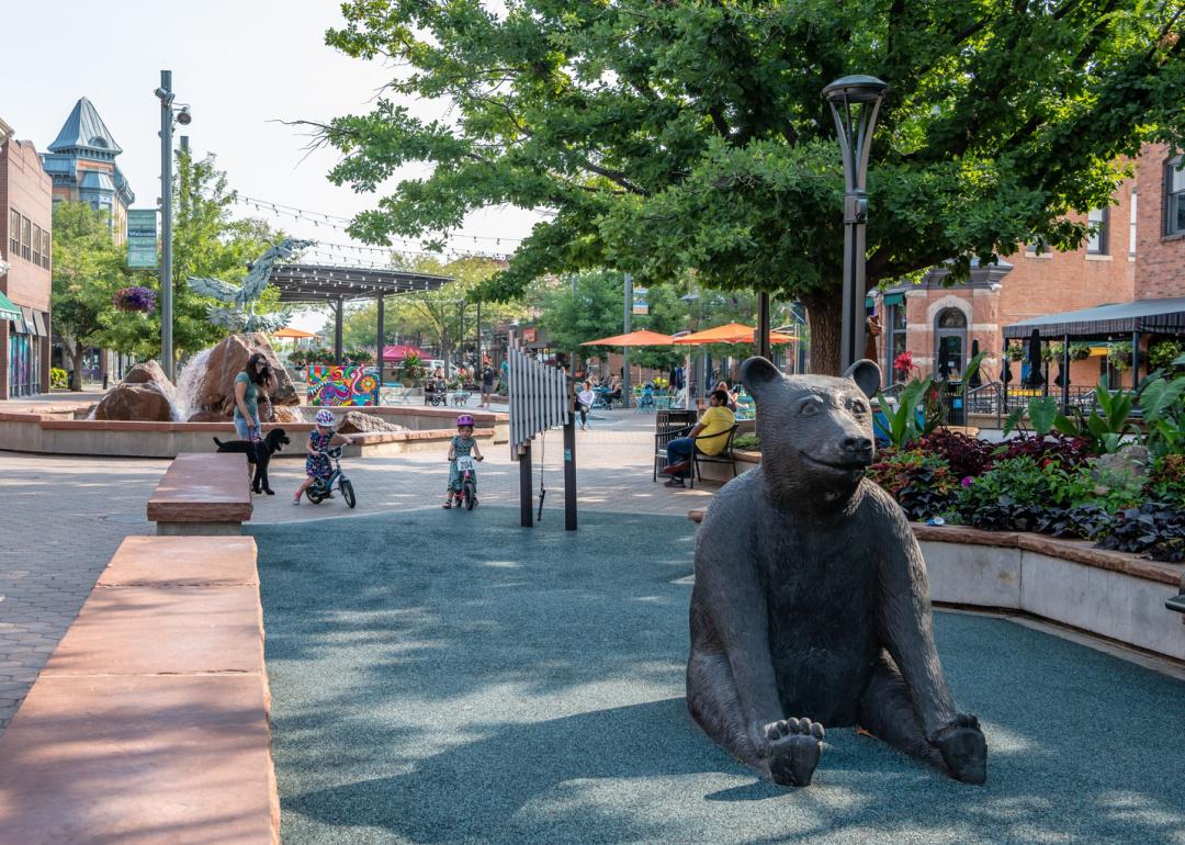 A family with a dog plays in Old Town Square in Fort Collins, Colorado.