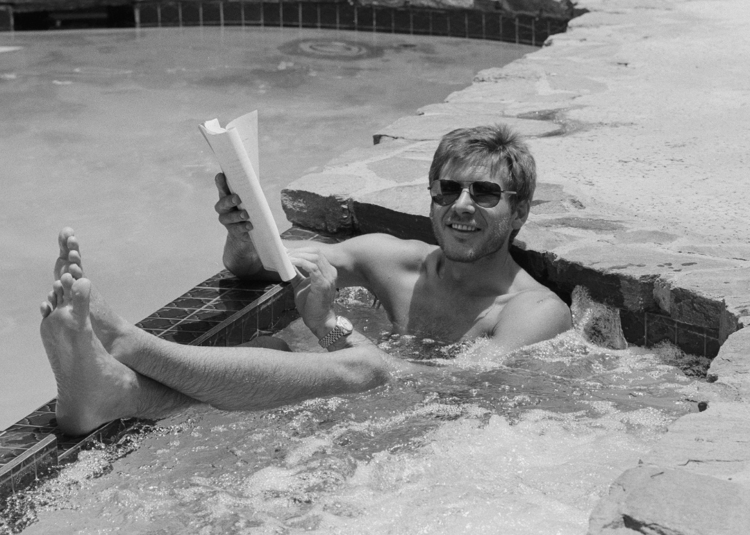 Harrison Ford poses in his pool with a script