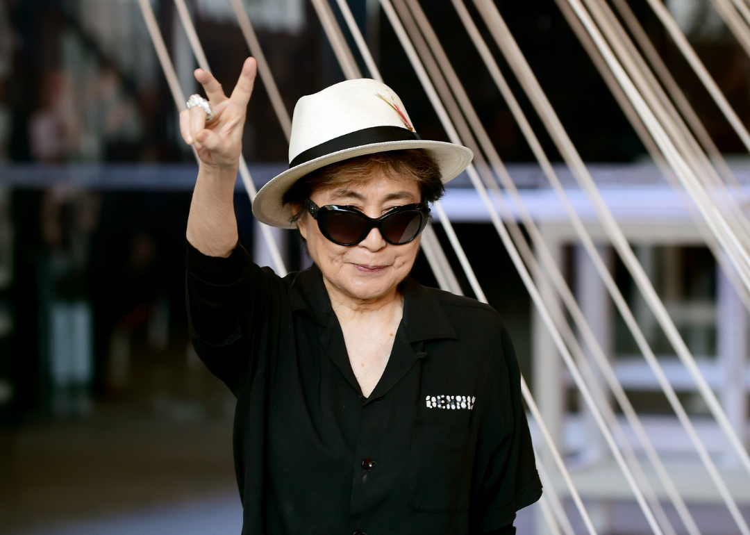 Yoko Ono gives the peace sign at an event.