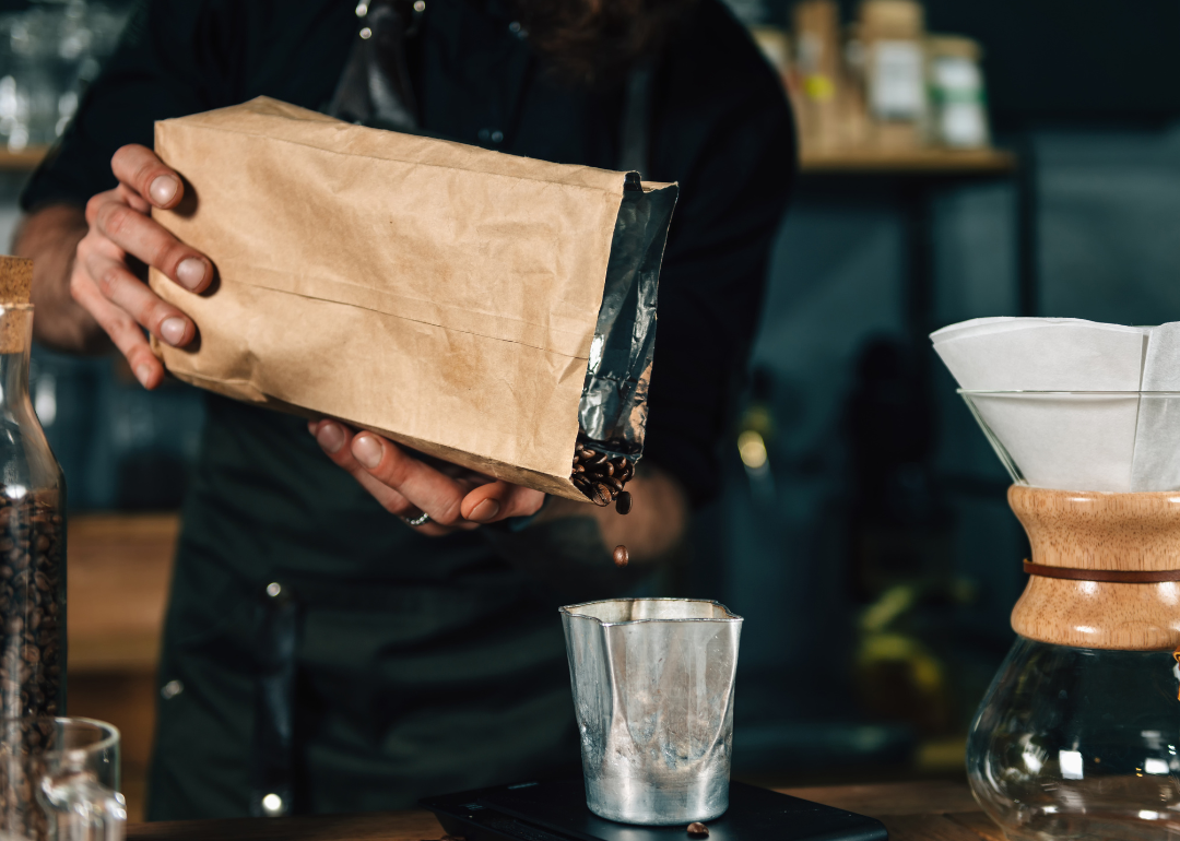 Barista pouring coffee beans.