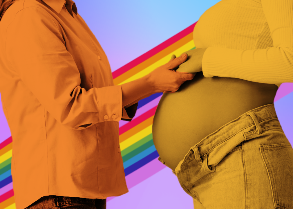 Doula holding hands of pregnant woman with rainbow background.