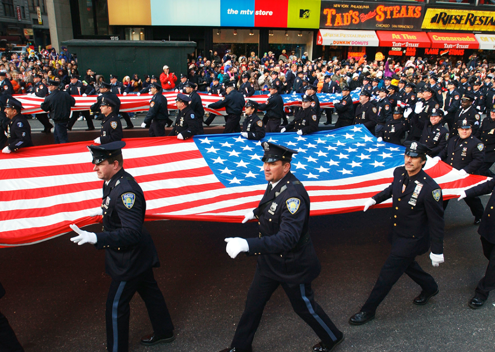 New York City Police Department officers carry large American flags in Times Square.