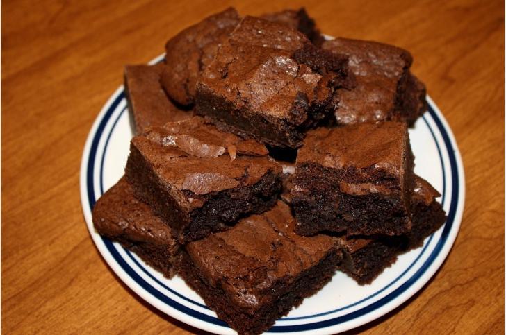 Chocolate brownies piled on a plate.