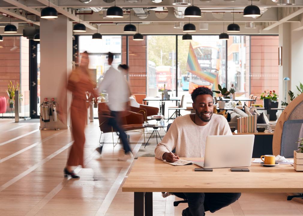 A man works at a laptop in a lobby 