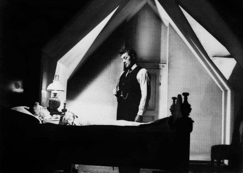 Shelley Winters and Robert Mitchum in a dramatically lit bedroom on the set of "The Night of the Hunter"