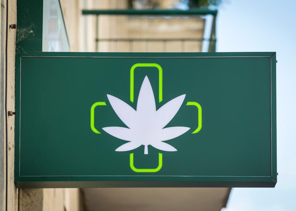 Green cross symbol on sign indicating a dispensary. 