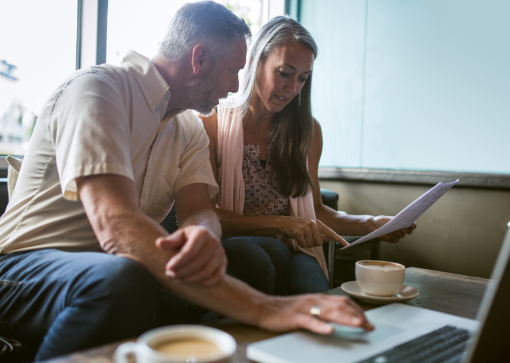 A middle-aged couple reviews financial documents.