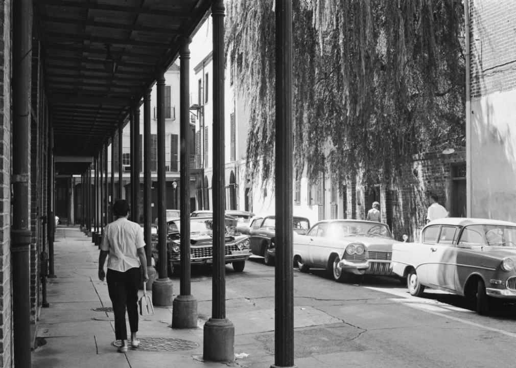 A woman walks down a narrow street in the French Quarter of New Orleans in the 1960s