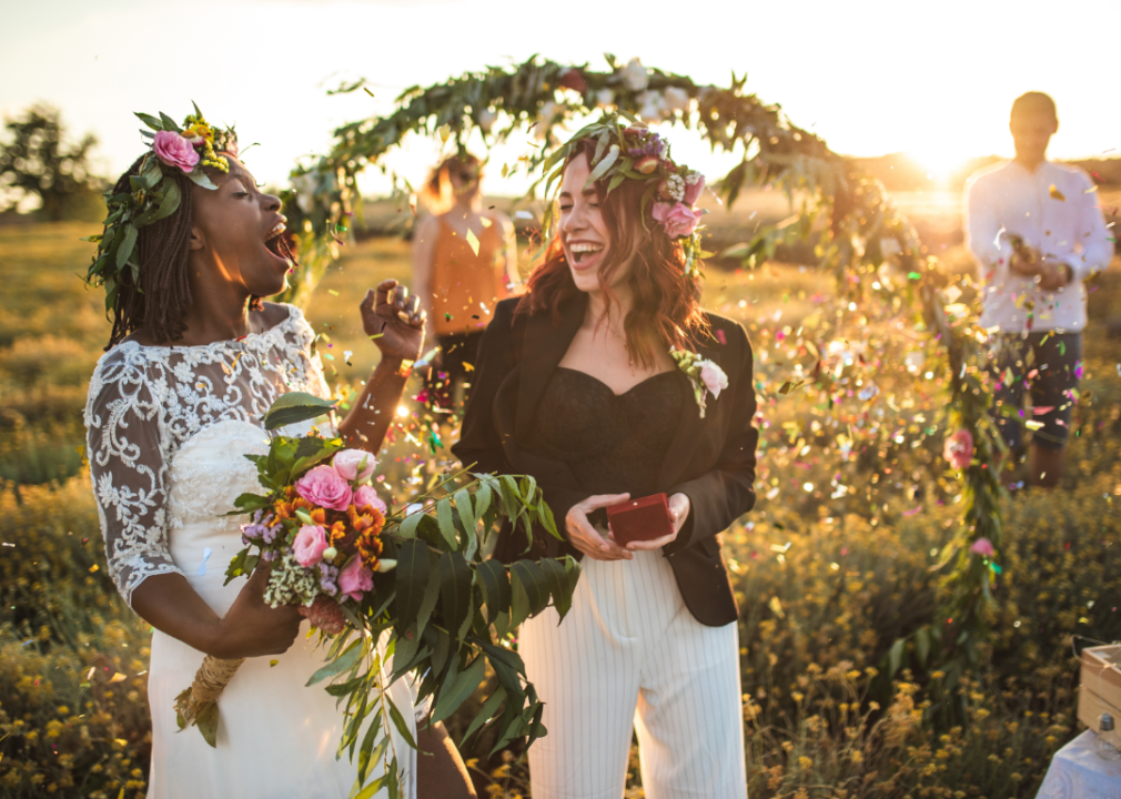 Two women smiling during an outdoor wedding ceremony