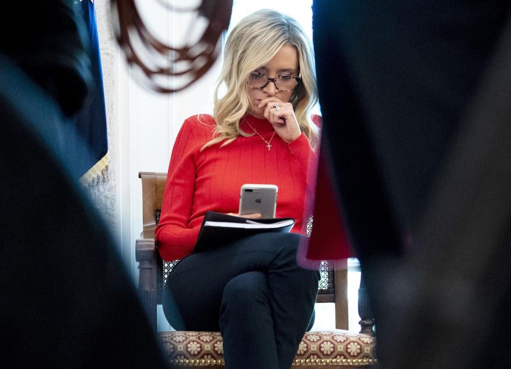 White House Press Secretary Kayleigh McEnany looks at her smart phone as U.S. President Donald Trump hosts Texas Governor Greg Abbott during the novel coronavirus pandemic in the Oval Office at the White House May 07, 2020 in Washington, DC.