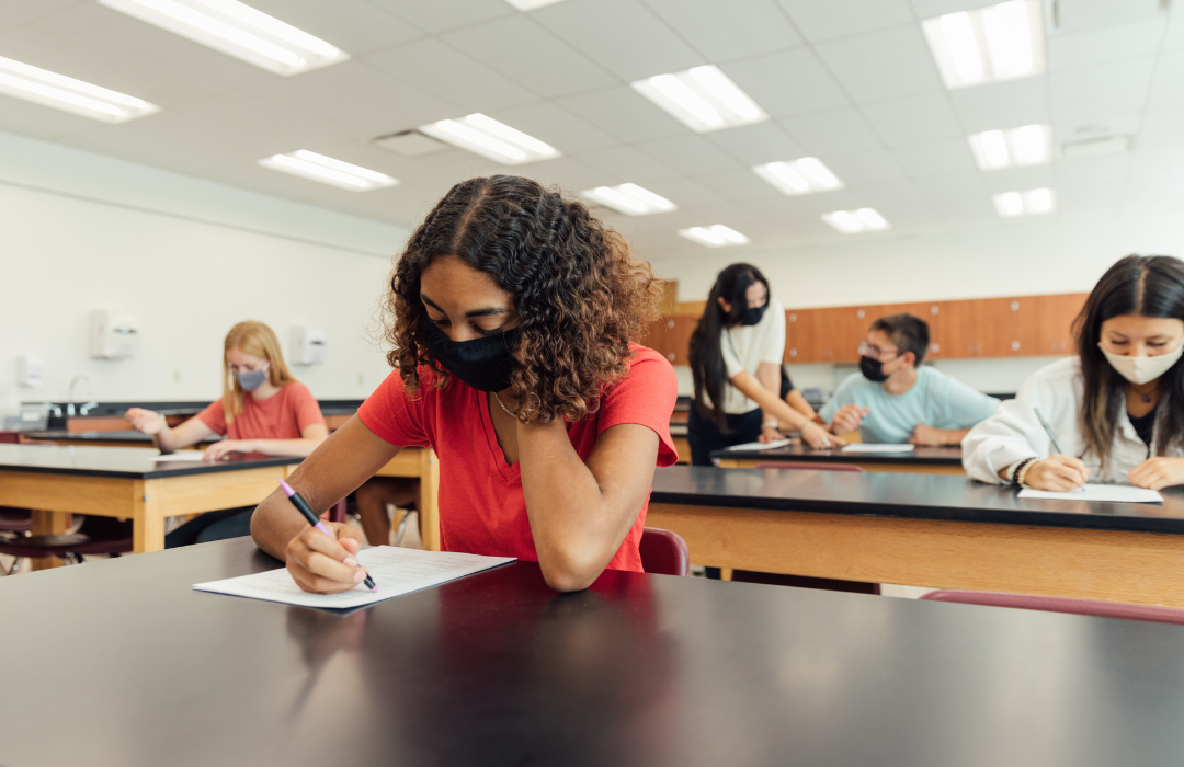 Female high school student wearing face mask in class