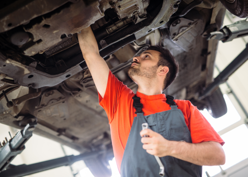 A mechanic works beneath a car