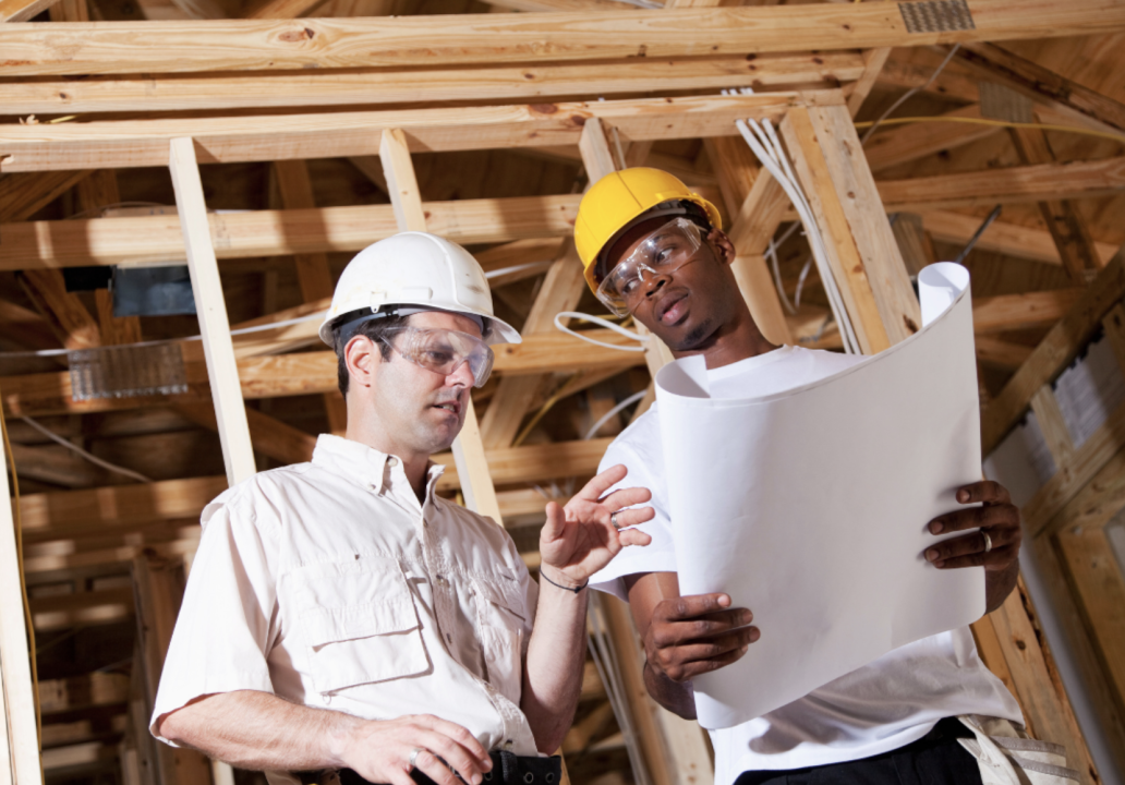 Two contractors work on a construction site