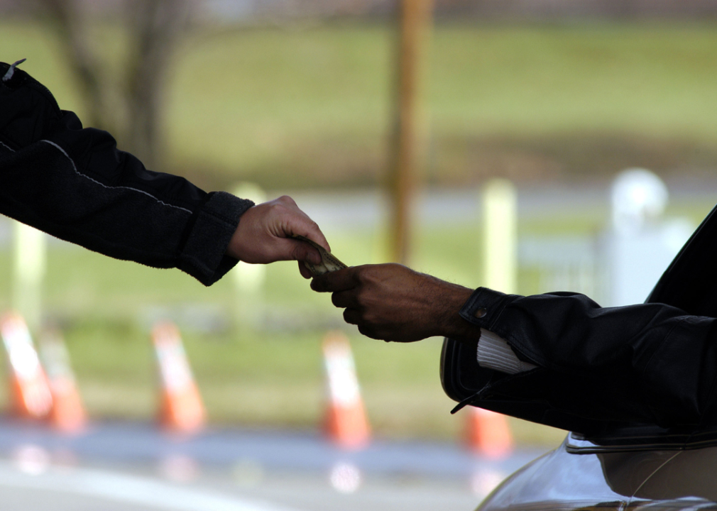 Hand reaches from car to pay toll attendant