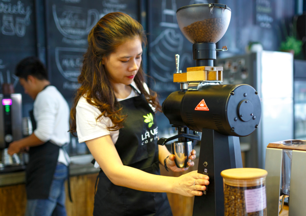 A barista grinding coffee beans