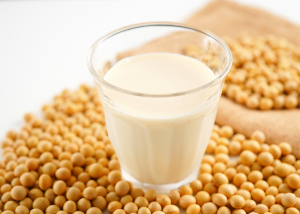 A glass of soy milk among soy beans