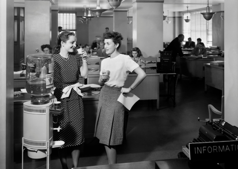 Two women chat by the office water cooler in the 1940s
