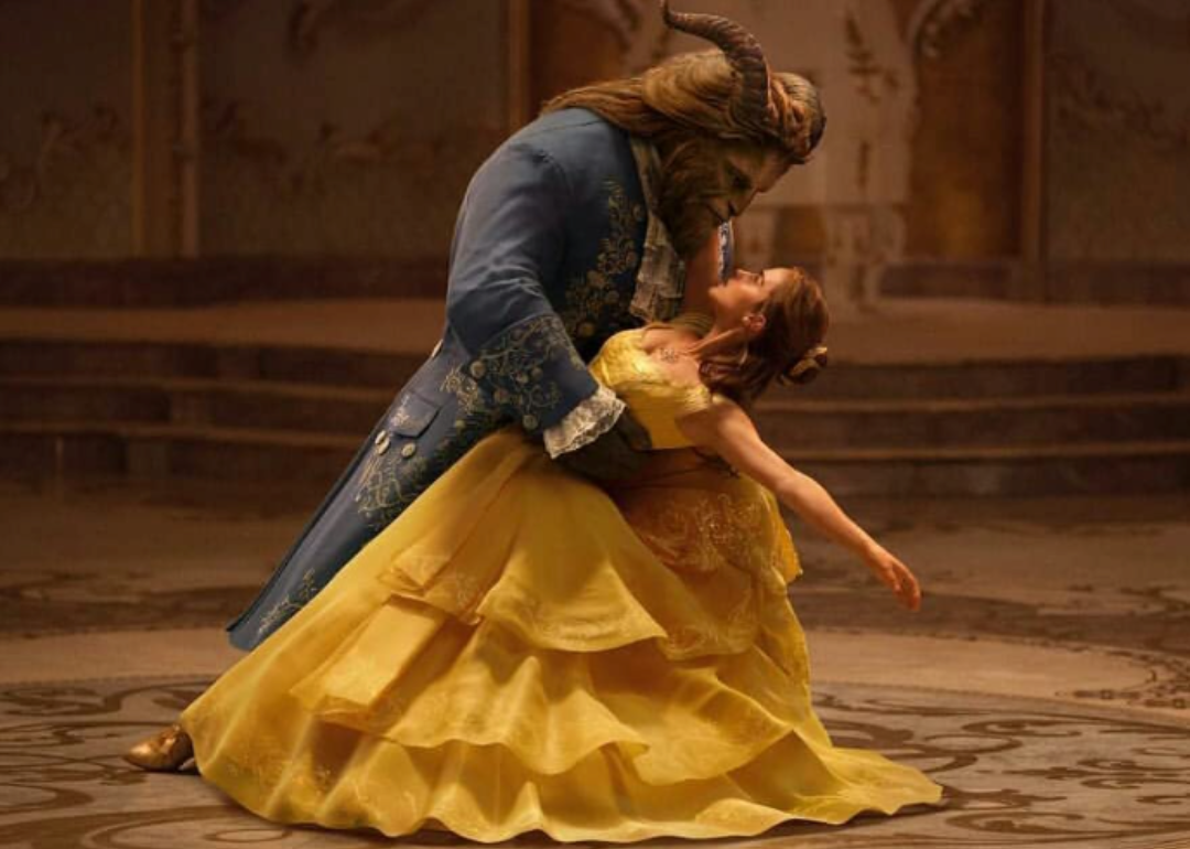 Emma Watson, as Beauty, in a yellow gown dancing with the beast.