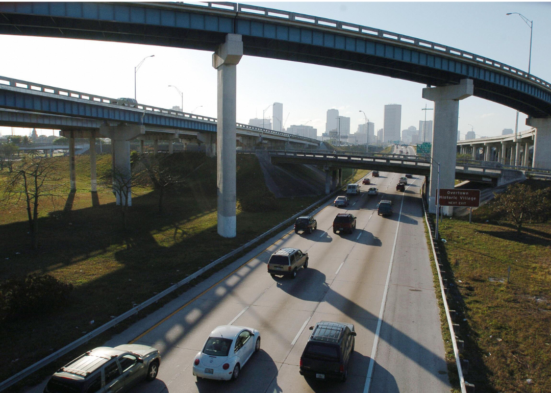 Cars driving by Overtown exit on interstate toward Miami skyline