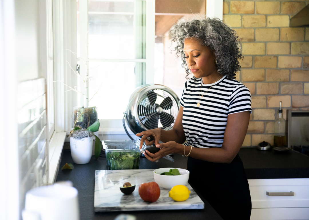 A woman preparing a healthy meal with lots of vegetables