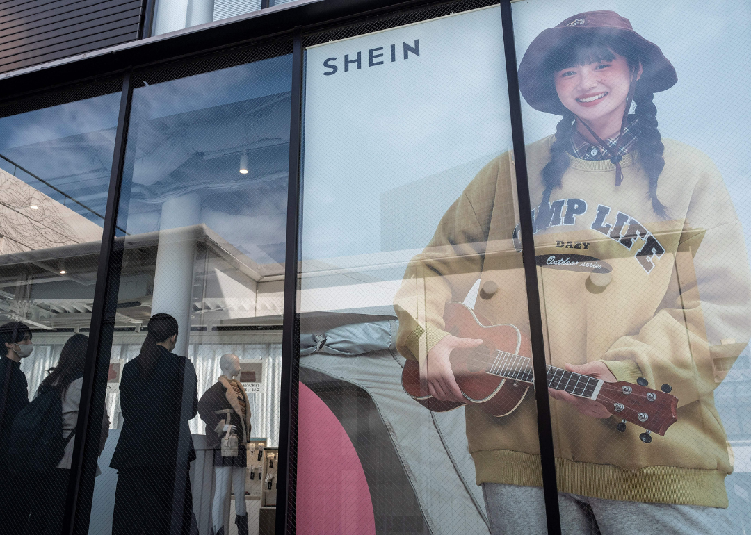 Customers inside a Shein shop with a big happy display in the window.