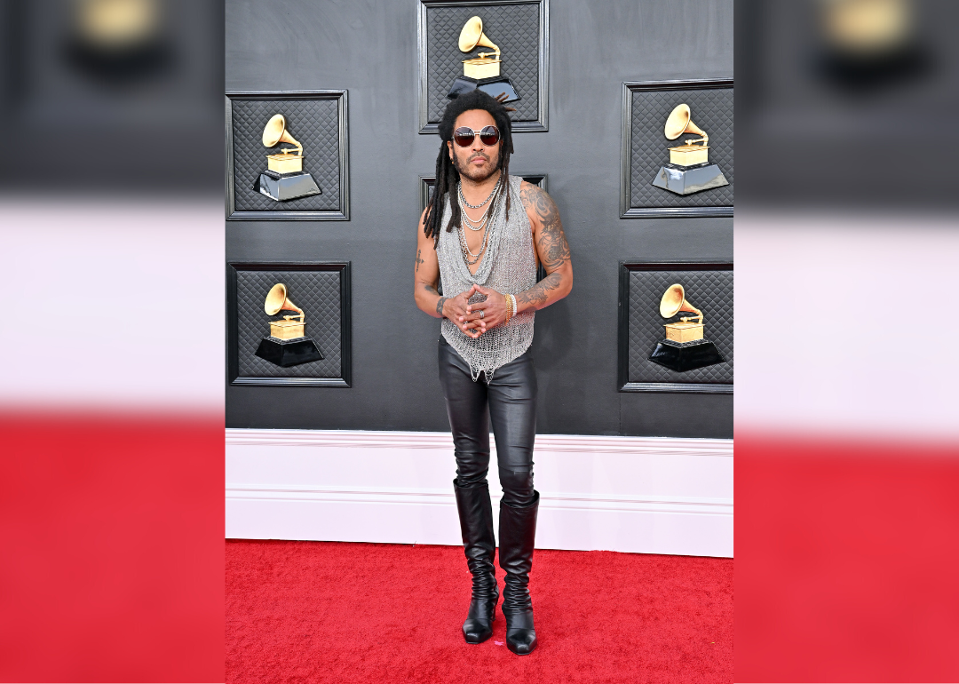 Lenny Kravitz in a silver chain shirt and black leather pants and sunglasses.