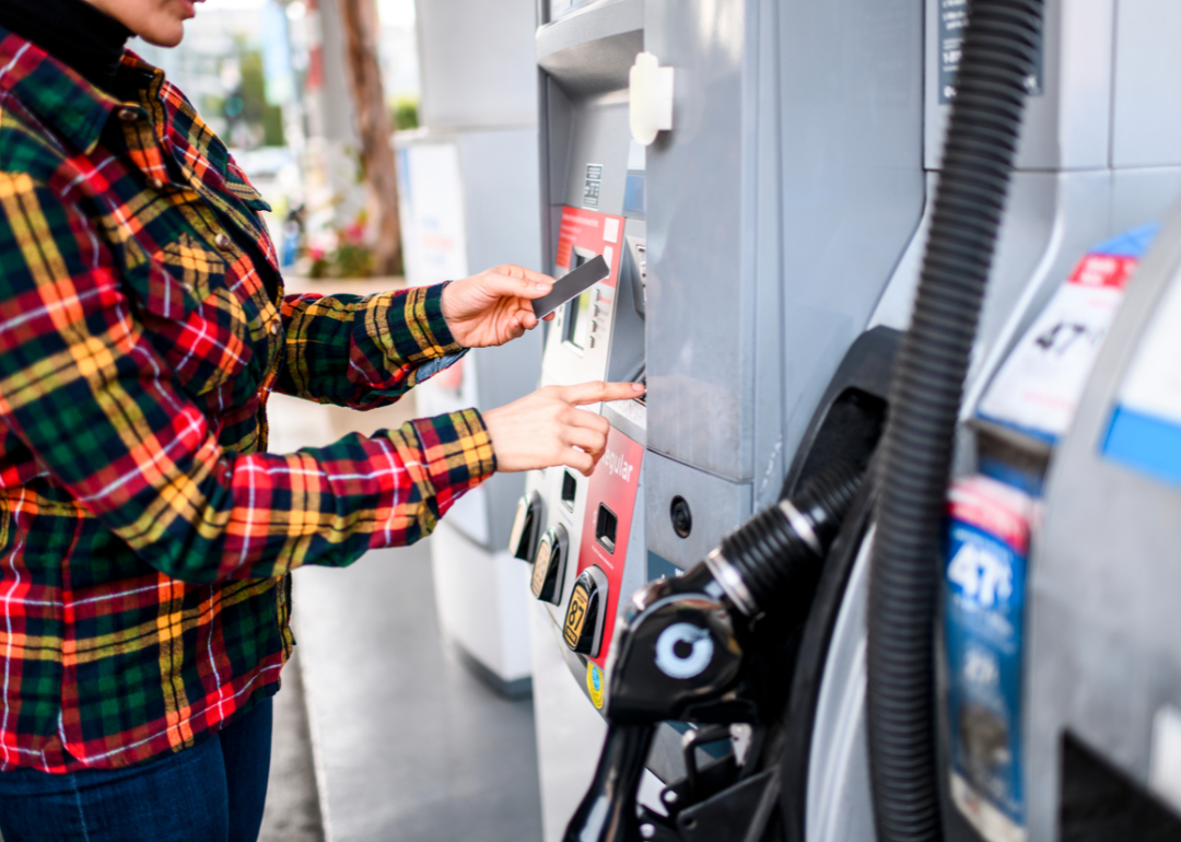 Person paying with a credit card at a gas pump.
