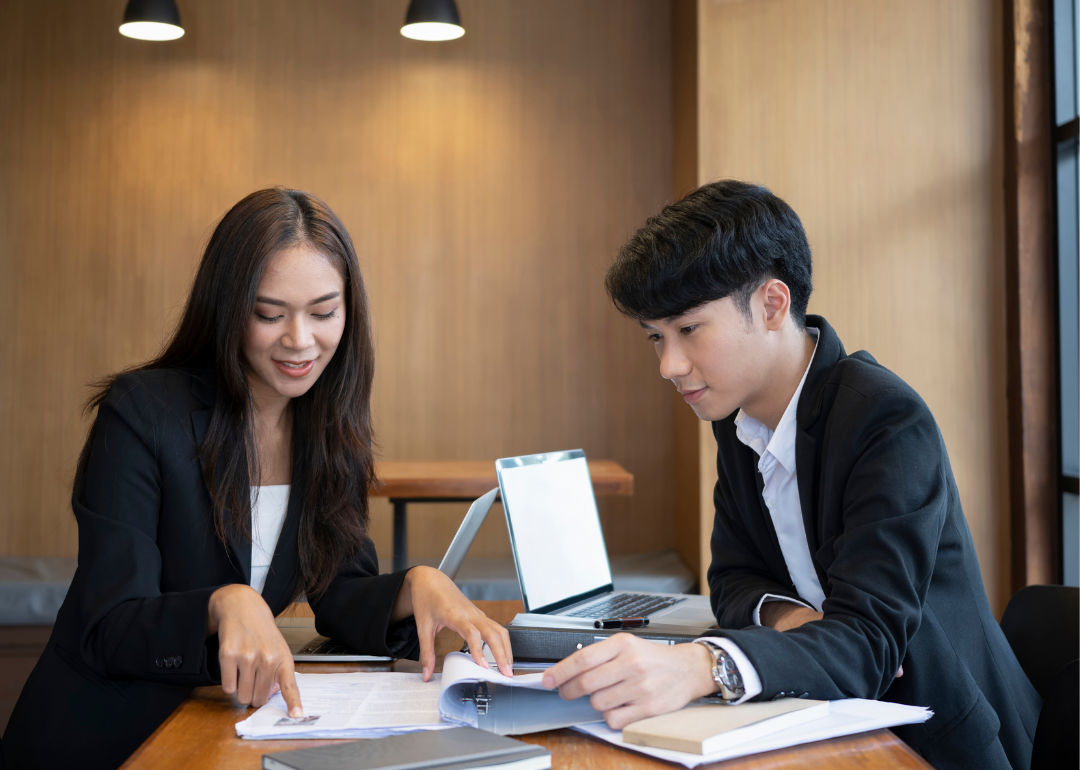 Two HR professionals review resumes and files.