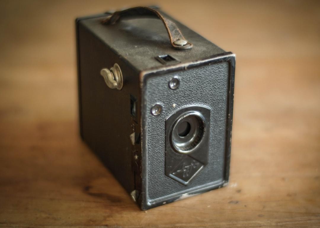A vintage pinhole camera on a wooden surface.