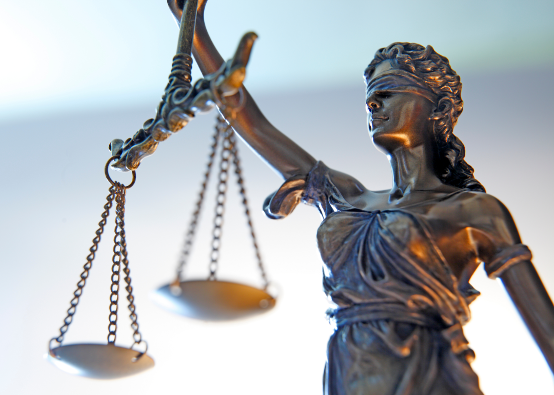 Image shows a closeup of a bronzed Lady Justice statue