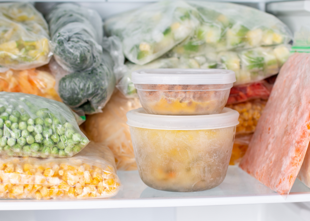 Plastic bags and containers contain a variety of foods in a freezer.