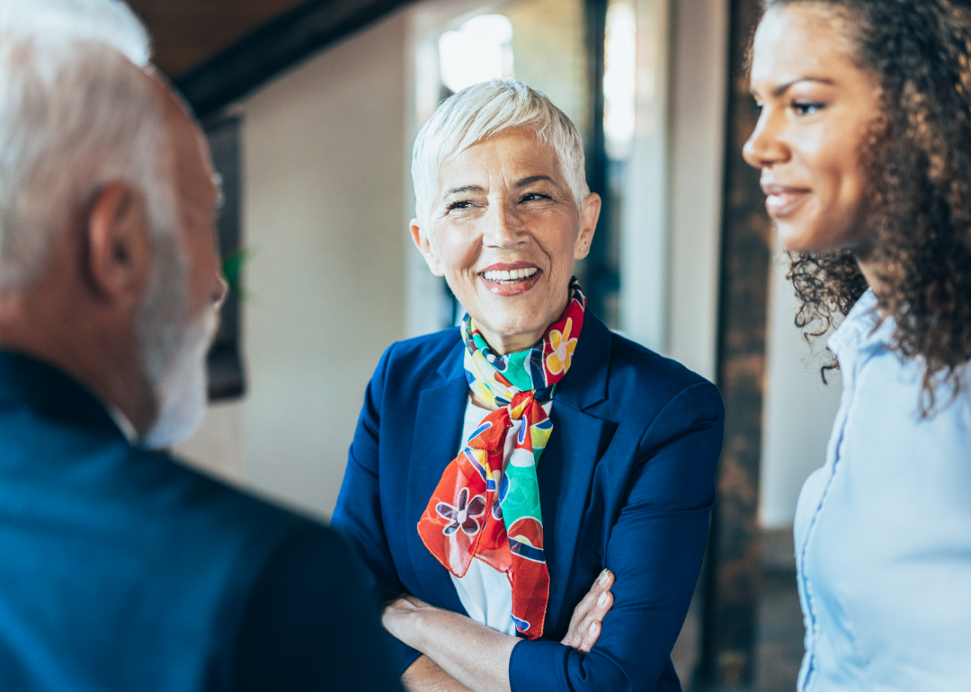 An older couple engages in conversation and laughter with a younger woman.