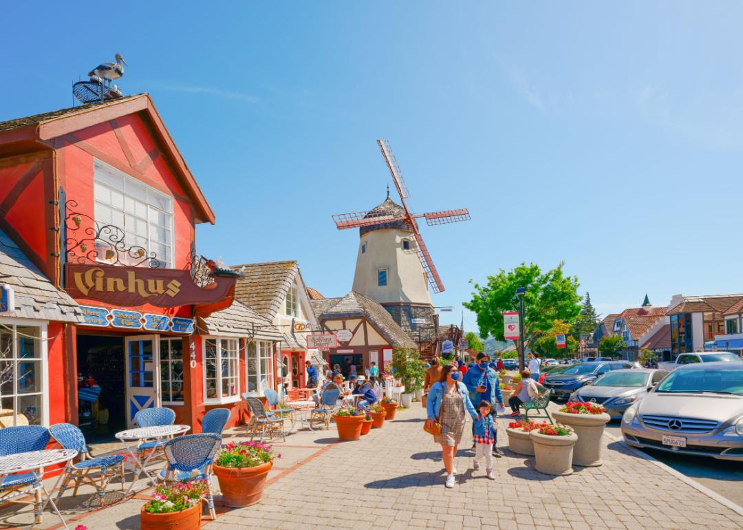 Tourists walk along the main street in Solvang, a beautiful small town in California, known for its traditional Danish-style architecture.