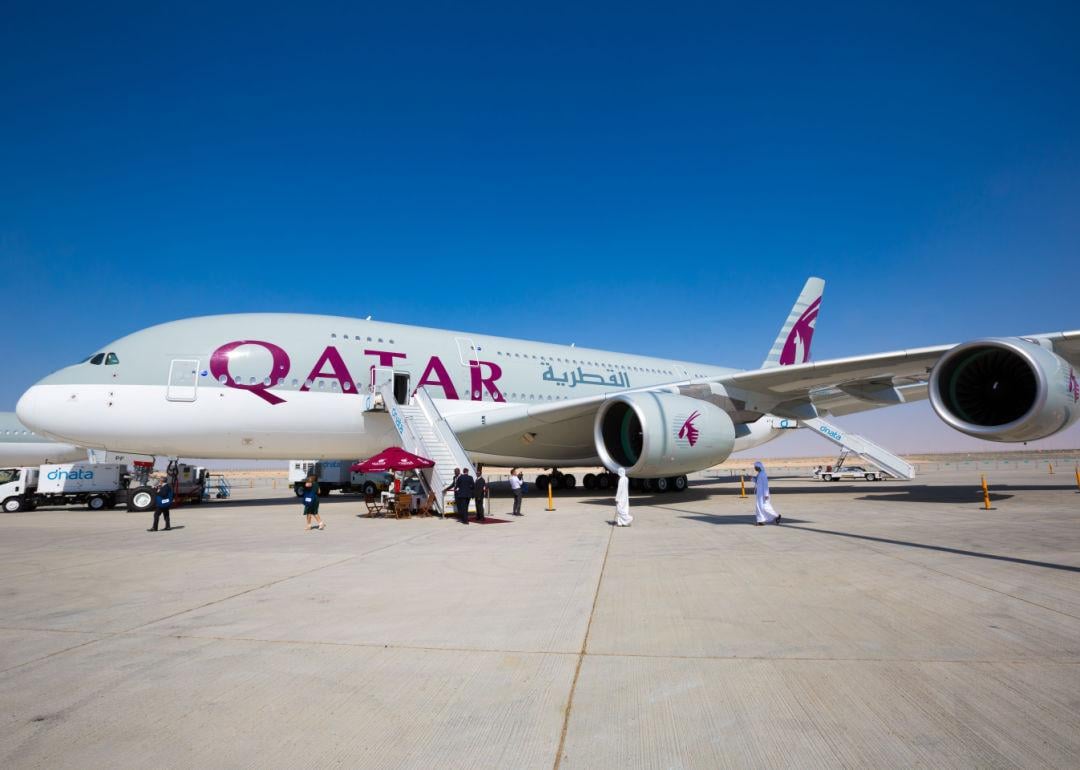 A Qatar Airways jet rests on the tarmac.