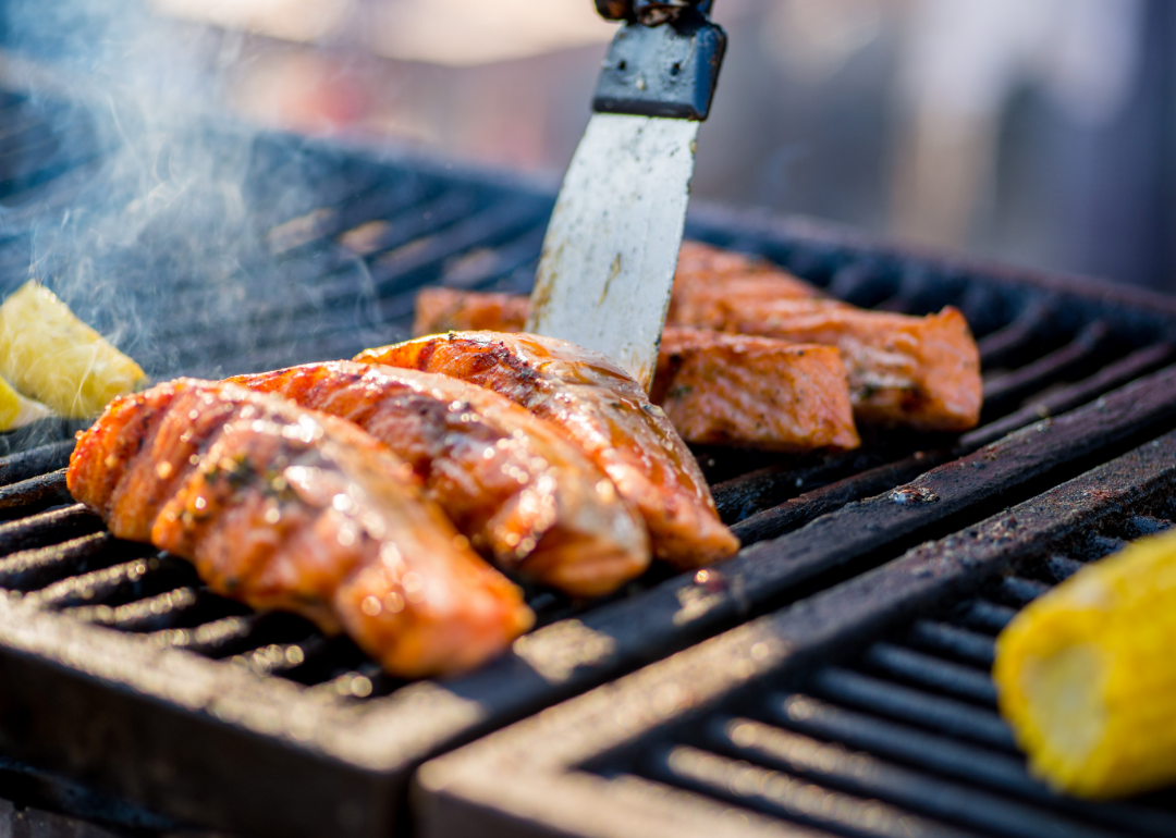 Salmon and corn cobs being grilled.