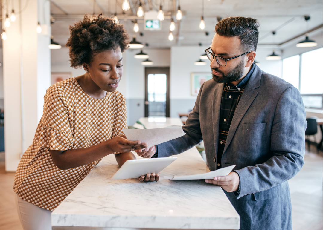 Two business owners review paperwork in an office. 