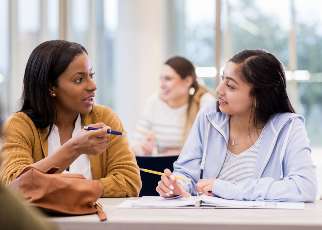 A tutor interacting with a student in a classroom setting.