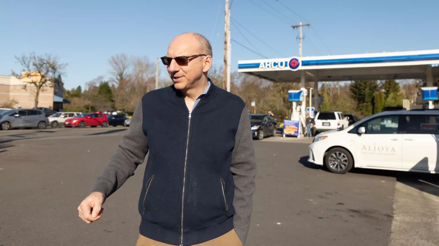 Matthew Metz, founder of Coltura, walks in the paved area of a gas station.