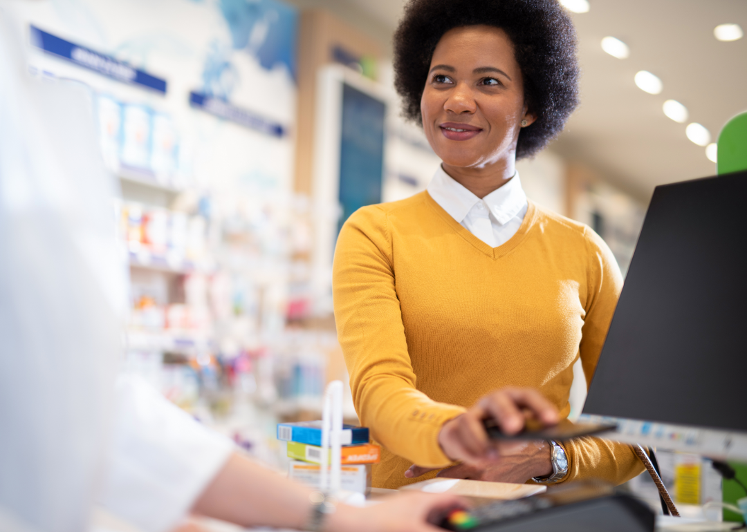 Where basic medical care costs the most A woman pays for medicine at a pharmacy.