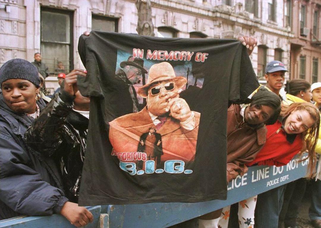 A man displays a T-shirt tribute to rapper Biggie Smalls at rapper's Brooklyn memorial service in 1997.