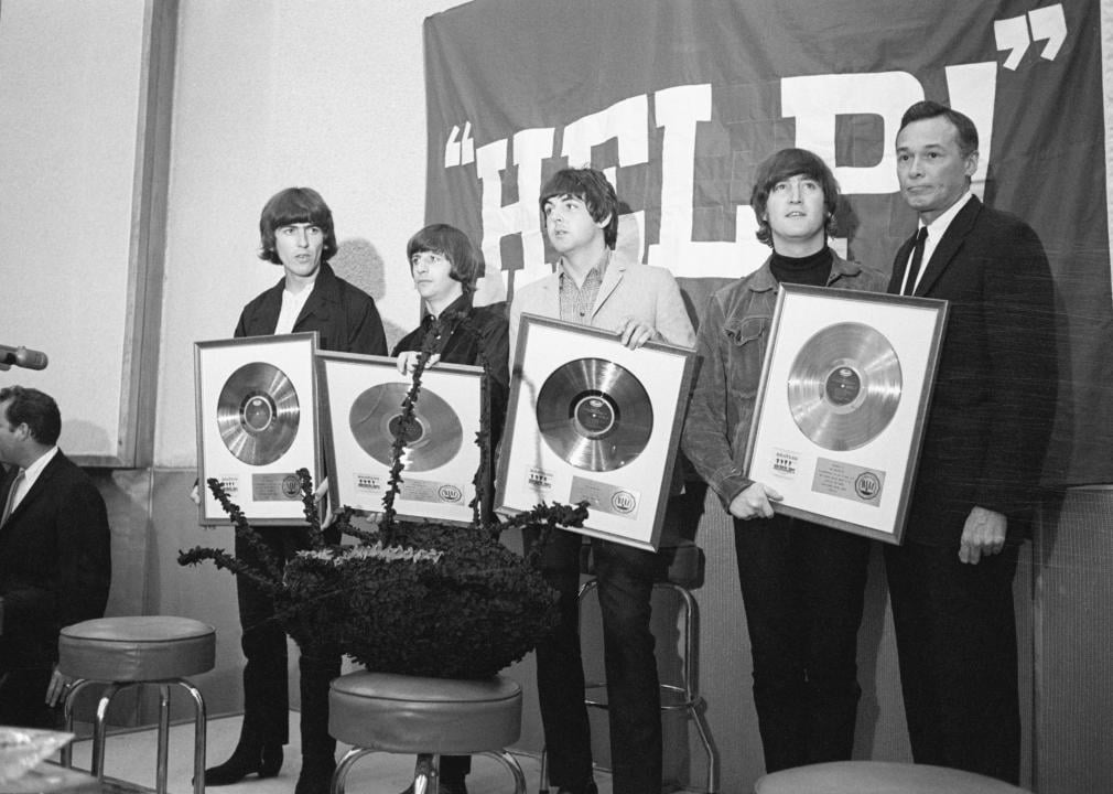 The Beatles show off their golden records during a news conference for the 1965 film Help!. 