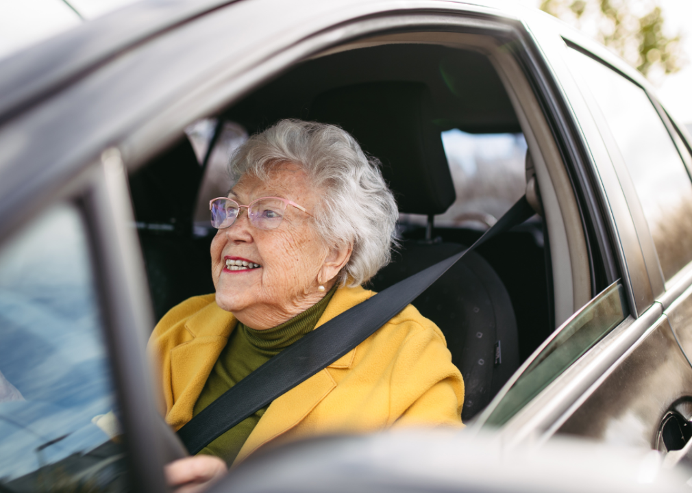 An gray-haired lady driving a car