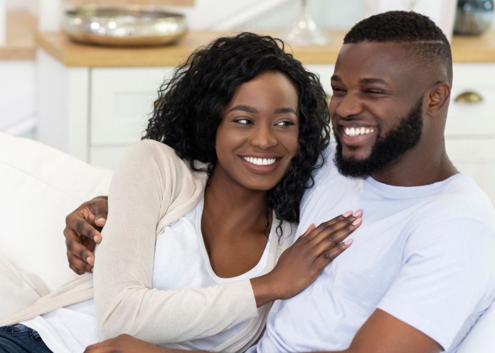 Black couple embracing on a couch.