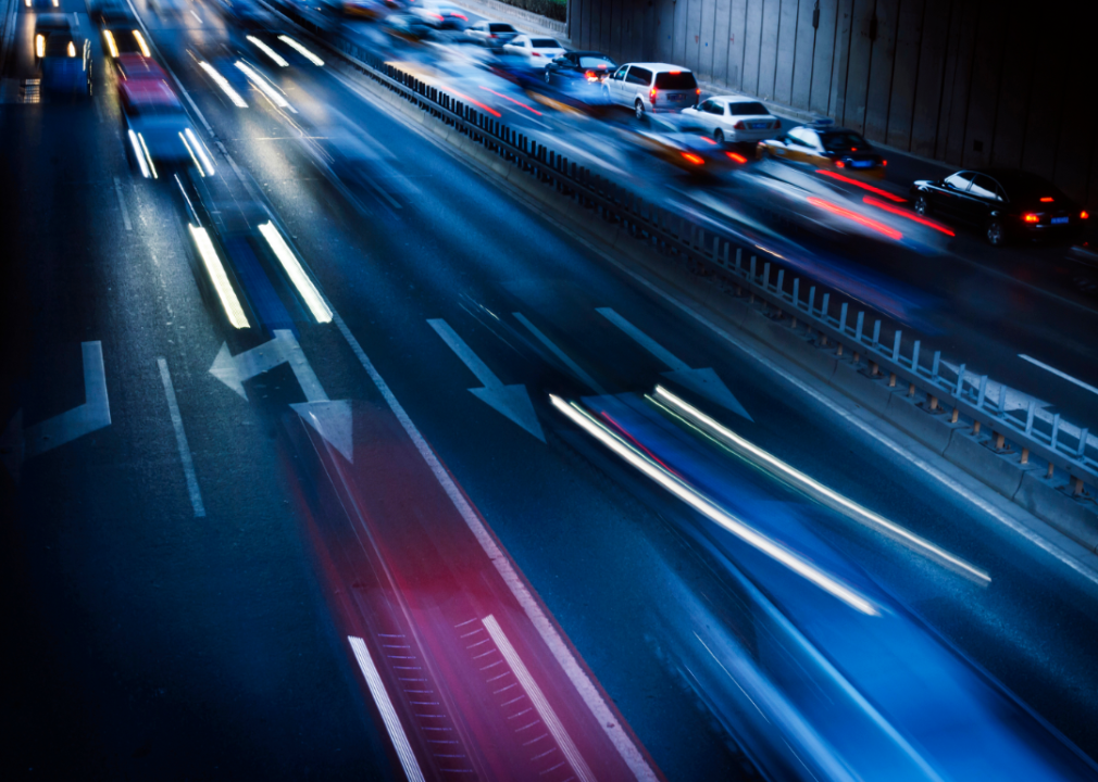 An overhead shot motion blur of car headlights changing lanes at night.