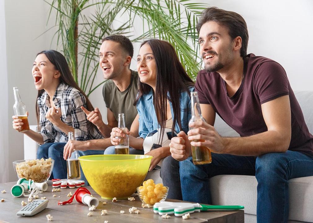group of 4 friends paying close attention to TV