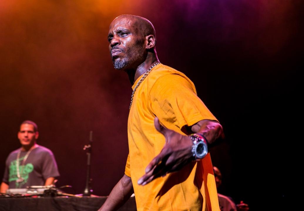 Rapper DMX performing onstage in yellow T-shirt.