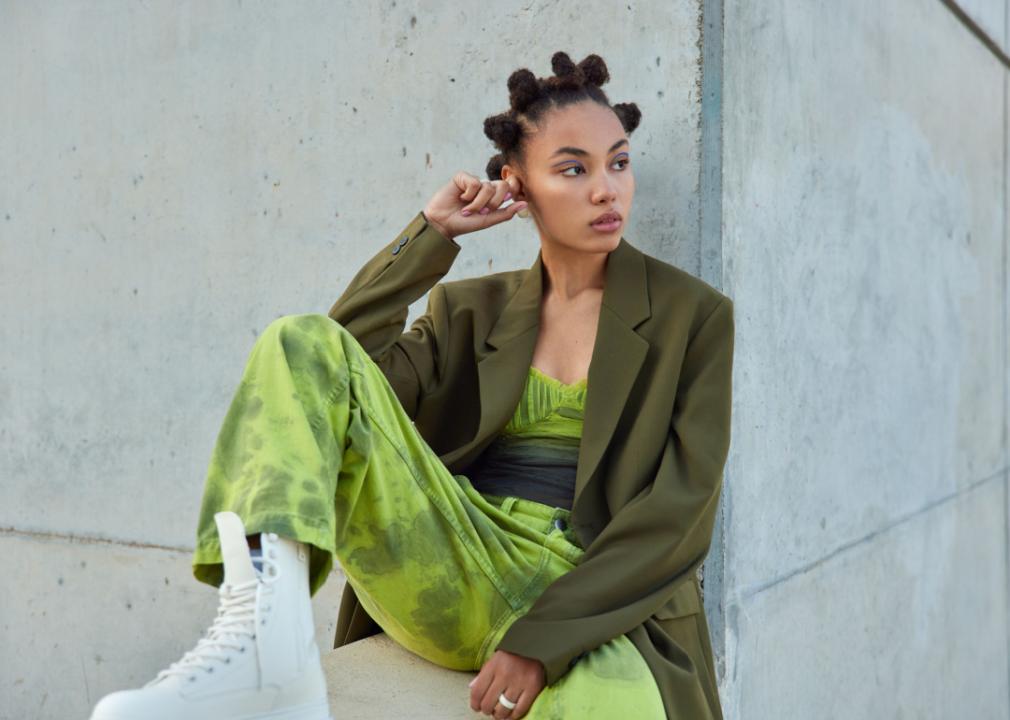 Stylish woman seated in a  green outfit.