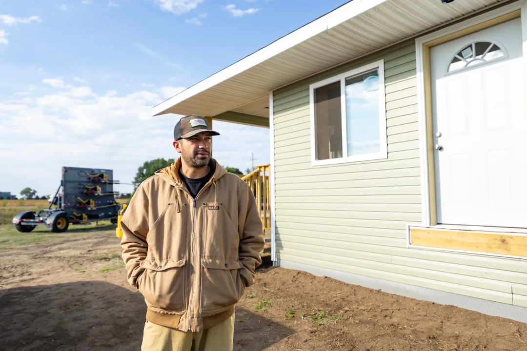 Danny Desjarlais stands next to a newly built duplex 